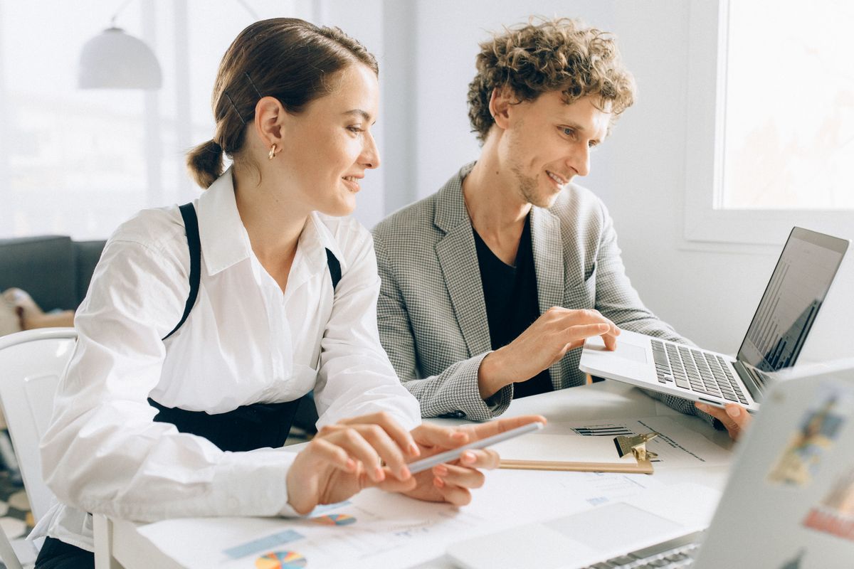 Two colleagues working together on their laptops